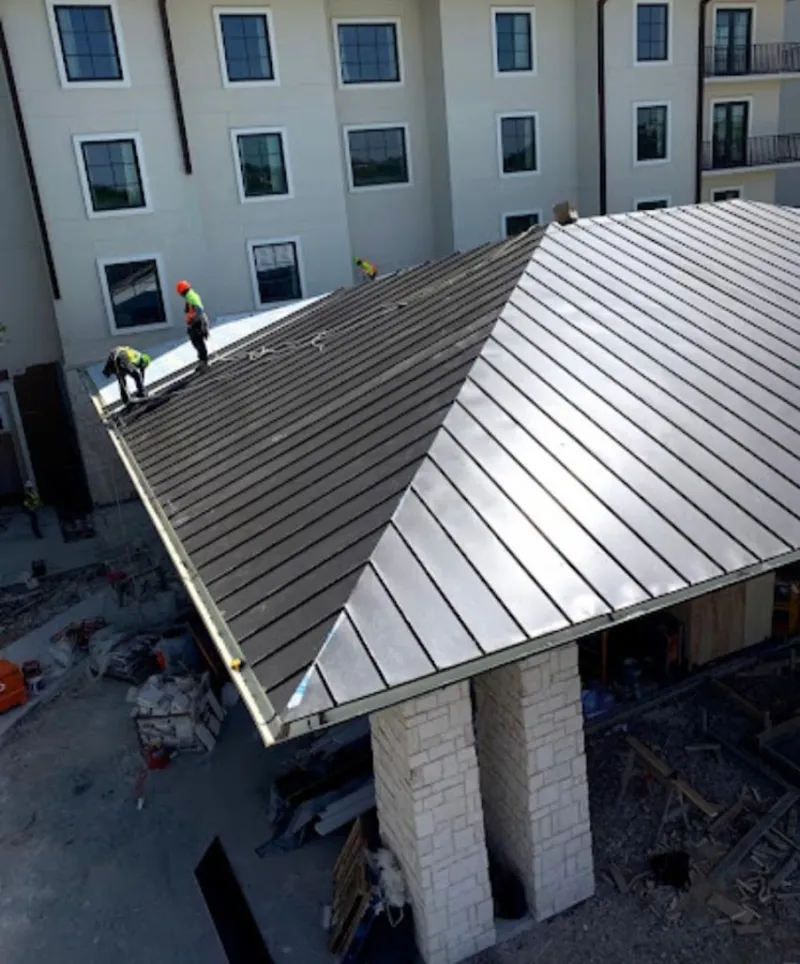 Crew installing standing seam metal roof panels on a commercial project in Wekiwa Springs